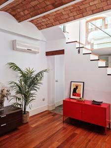 a living room with a red cabinet and a staircase at Loft & private Rooftop with BBQ in Seville