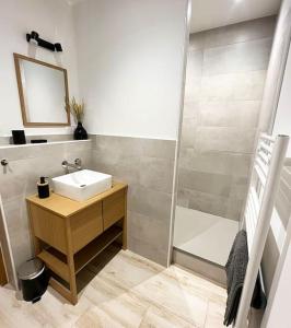 uma casa de banho com um lavatório e um chuveiro em Maison climatisée toute équipée em Montchanin