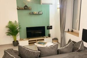 a living room with a couch and a tv at Maison climatisée toute équipée in Montchanin