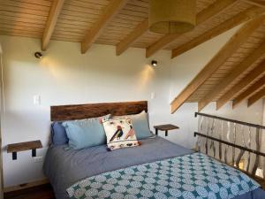 een slaapkamer met een bed in een kamer met houten plafonds bij Refugio Huerta Los Maquis in Puerto Guadal