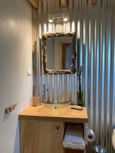 a bathroom with a glass sink and a mirror at Refugio Huerta Los Maquis in Puerto Guadal