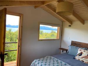 a bedroom with a bed and a window at Refugio Huerta Los Maquis in Puerto Guadal