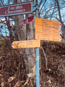 a street sign with signs on it in front of a tree at Boutique Chalet Panoramic Views Hot Tub in Vers L'Eglise