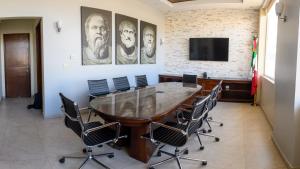 uma sala de conferências com uma grande mesa de madeira e cadeiras em Hotel Santorian em Hermosillo