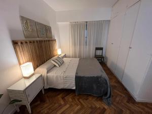 1 dormitorio con 1 cama, 1 mesa y 2 lámparas en De Esa HOME en Buenos Aires