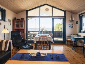 イェアティングにあるThree-Bedroom Holiday home in Esbjerg V 2のリビングルーム(テーブル付)が備わり、海の景色を望めます。