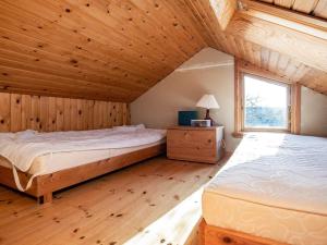イェアティングにあるThree-Bedroom Holiday home in Esbjerg V 2のウッドフロアの客室で、ベッド2台、窓が備わります。