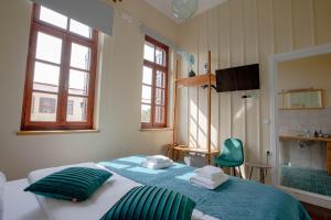 a bedroom with a large bed with green pillows at Ruby 'n Emerald studio's in Rethymno Town