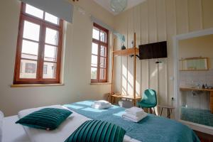 a bedroom with a large bed with green pillows at Ruby 'n Emerald studio's in Rethymno