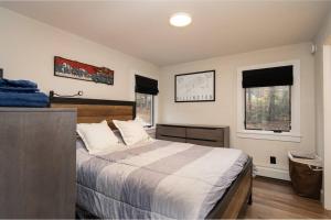 a bedroom with a large bed and two windows at Killington Ski Chalet - Newly Renovated in Killington