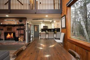 a large wooden table in a living room with a fireplace at Killington Ski Chalet - Newly Renovated in Killington