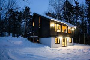 a small house in the snow at night at Killington Ski Chalet - Newly Renovated in Killington