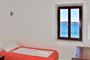 a bedroom with a window with a view of the ocean at Dream Beloc House Lopud Island in Lopud