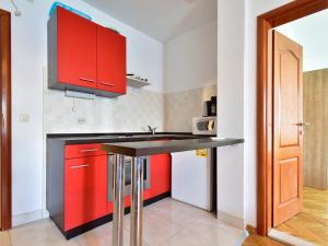 a kitchen with red cabinets and a black counter top at Dream Beloc House Lopud Island in Lopud Island