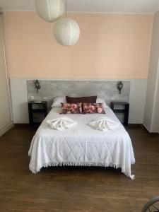 1 dormitorio con 1 cama blanca y 2 mesitas de noche en Colorado en Mendoza