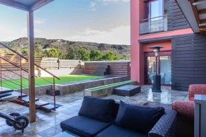 eine Terrasse mit einem Sofa und einem Tennisplatz in der Unterkunft VILLA rosa BENAHAVIS in Estepona