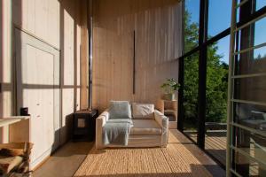 - un salon avec une chaise sur une terrasse couverte dans l'établissement Silvestre lodge, à Buchupureo