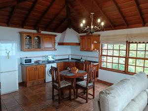 cocina con mesa y sofá en Casa Las Caracolas, en Mazo