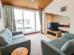 a living room with two couches and a television at 1 South Snowdon Wharf in Porthmadog