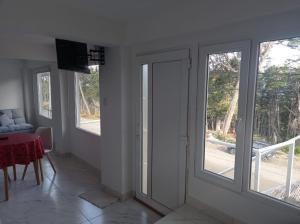Sala de estar con 3 ventanas y mesa con sofá en ALAKALUFES House en Ushuaia