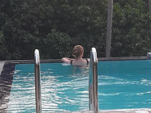 un hombre está en una piscina en THE HIDEOUT KURUNEGALA, en Kurunegala