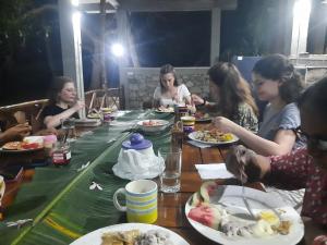un grupo de personas sentadas alrededor de una mesa comiendo comida en THE HIDEOUT KURUNEGALA, en Kurunegala