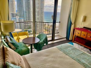 a hotel room with a bed and a view of the ocean at High Floor Ocean View at Surfers Paradise - Hotel Studio in Gold Coast