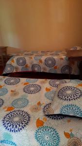 Una cama con un edredón azul y blanco. en Cabinas las Gemelas, en Pavones