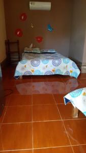 a bedroom with a bed and a tiled floor at Cabinas las Gemelas in Pavones