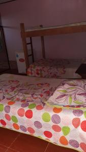a bed with a polka dot blanket on top of it at Cabinas las Gemelas in Pavones