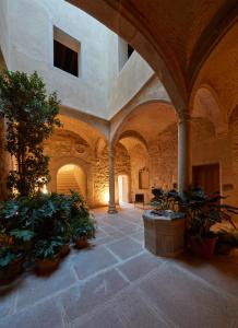 a large hallway with plants in a building at Casa Palacio PAREDES SAAVEDRA by ATRIO in Cáceres