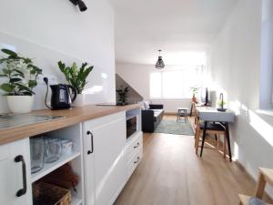 a kitchen with white cabinets and a dining room at Attic apartment Cathouse in Bratislava