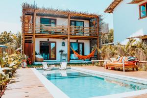 una casa con piscina frente a una casa en Heruê Vila Praia do Espelho, en Porto Seguro