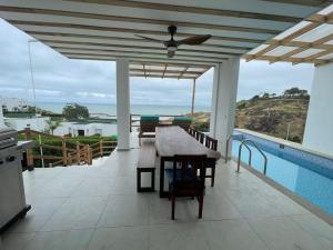 een patio met een tafel en uitzicht op de oceaan bij Jama Campay, Renta Casa de Lujo in Jama