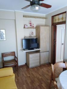 sala de estar con cama, TV y sofá en Departamento 2 ambientes Piso 14 Mucho sol y buena vista en Buenos Aires