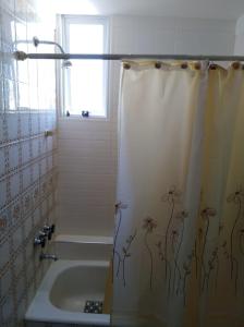baño con cortina de ducha con flores en Departamento 2 ambientes Piso 14 Mucho sol y buena vista en Buenos Aires