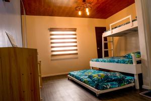 a bedroom with two bunk beds and a window at Puffer Isle Resort in Dingalan