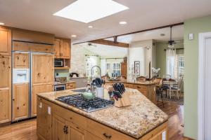 La cuisine est équipée de placards en bois et d'un four avec plaques de cuisson. dans l'établissement 3485 Avalon by the Sea home, à Monterey