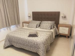 een slaapkamer met een bed met een deken en kussens bij Beril D17 in Adeje +20 foto's