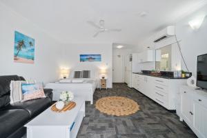 sala de estar con sofá, cama y cocina en The Resort at Dolphin Heads, en Mackay