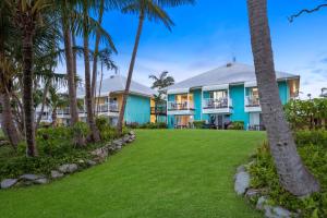 uma vista exterior de uma casa com palmeiras em The Resort at Dolphin Heads em Mackay