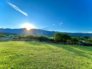 un champ d'herbe avec le soleil en arrière-plan dans l'établissement Casa de Campo La Montaña, à Tarija