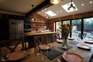 una cocina con una mesa de madera y un jarrón de flores en St Valentine - Fun away with loved ones en Manningtree