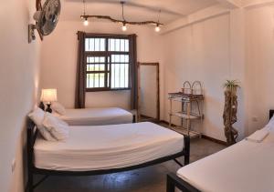 Habitación con 2 camas y ventana en Hostal Don Cenobio, en Flores