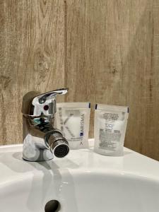 a bathroom sink with a faucet and two boxes of soap at La Tombola in Naples