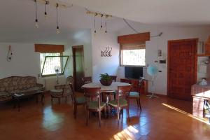 een woonkamer met een tafel en stoelen bij Le Magnolie Villa esclusiva vicino Roma e il lago in Nepi