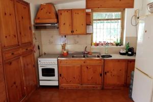 een keuken met houten kasten, een wastafel en een fornuis bij Le Magnolie Villa esclusiva vicino Roma e il lago in Nepi