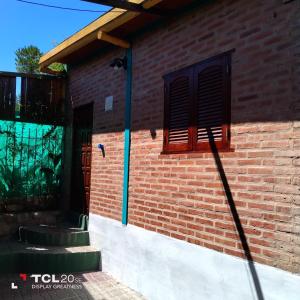 un edificio de ladrillo con una ventana en el lateral en Pecas house en Mina Clavero