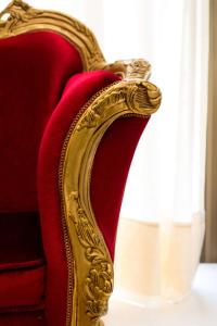 a red couch with a gold frame on it at Majestic Ponta Negra Beach,WorldHotels Elite in Natal