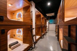 a room with wooden walls and a row of bunk beds at Jpod Capsule Hotel in Kota Kinabalu